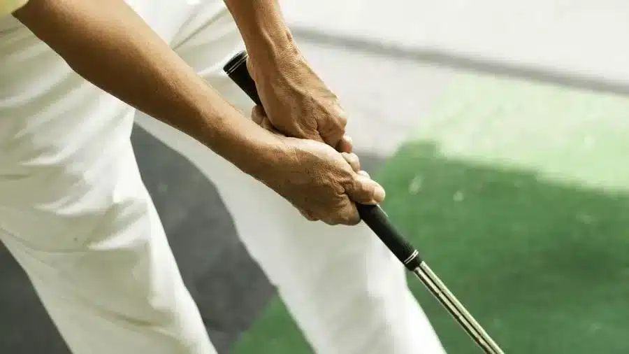 A person holding a golf club with a strong grip