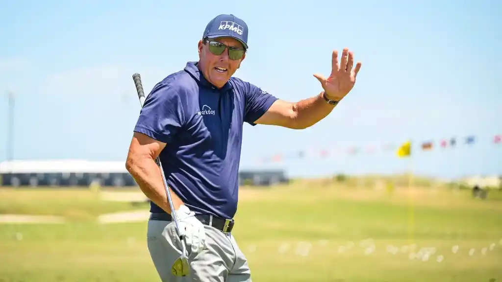 A view of Phil Mickleson waving his hand at a golf course