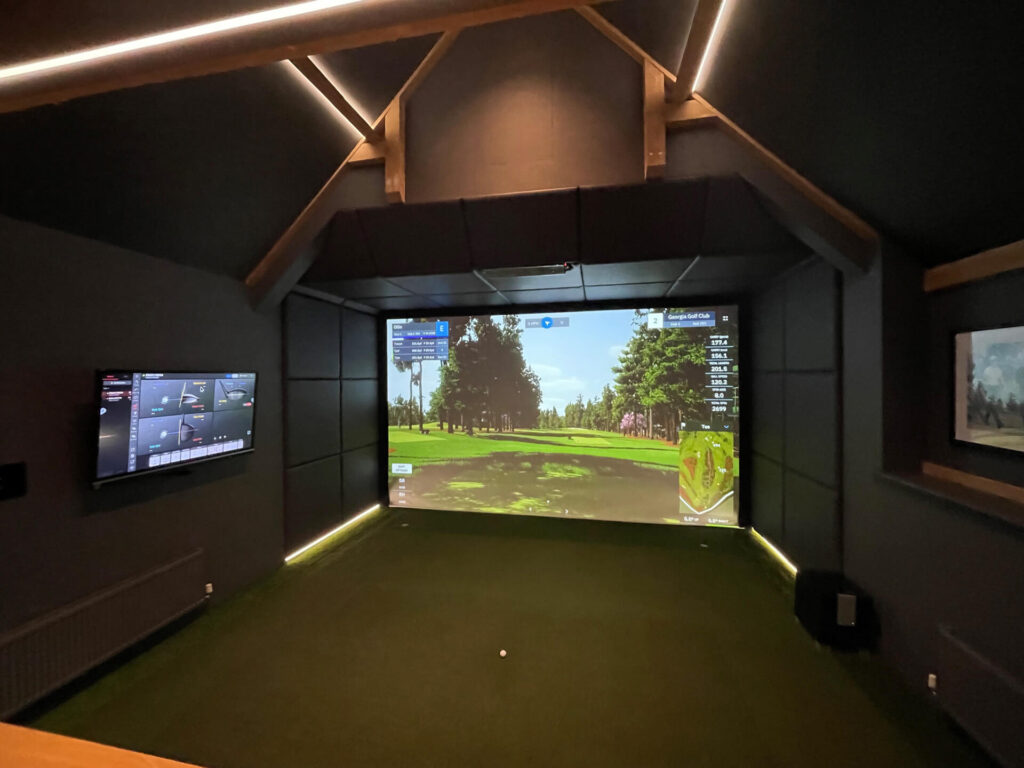 A view of a garage golf simulator with projector on