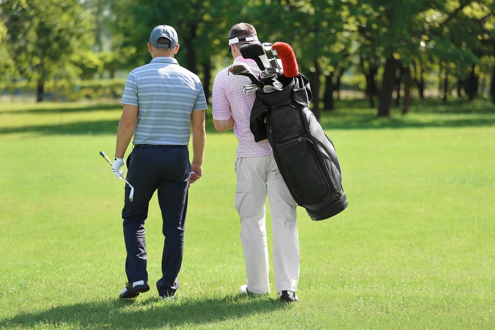 Young Men On Golf Course In Sunny Day