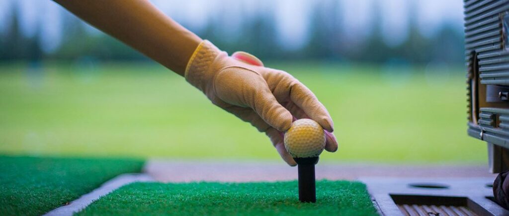 A close view of golf balls sitting in grass with tees