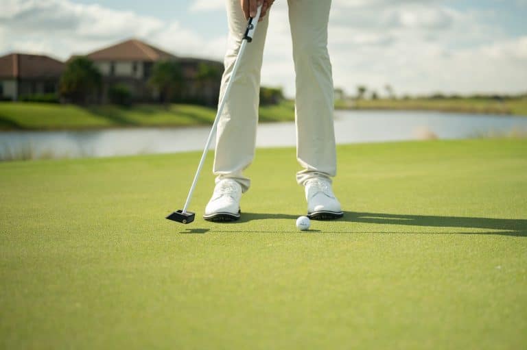 A person hitting the golf ball on a clean golf course