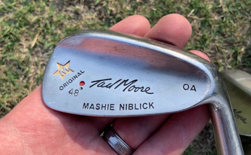 A person holding the mashie niblick golf club