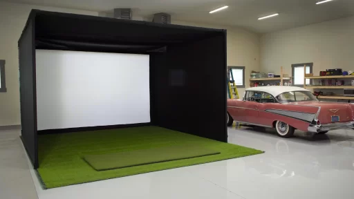 A view of an open garage golf simulator