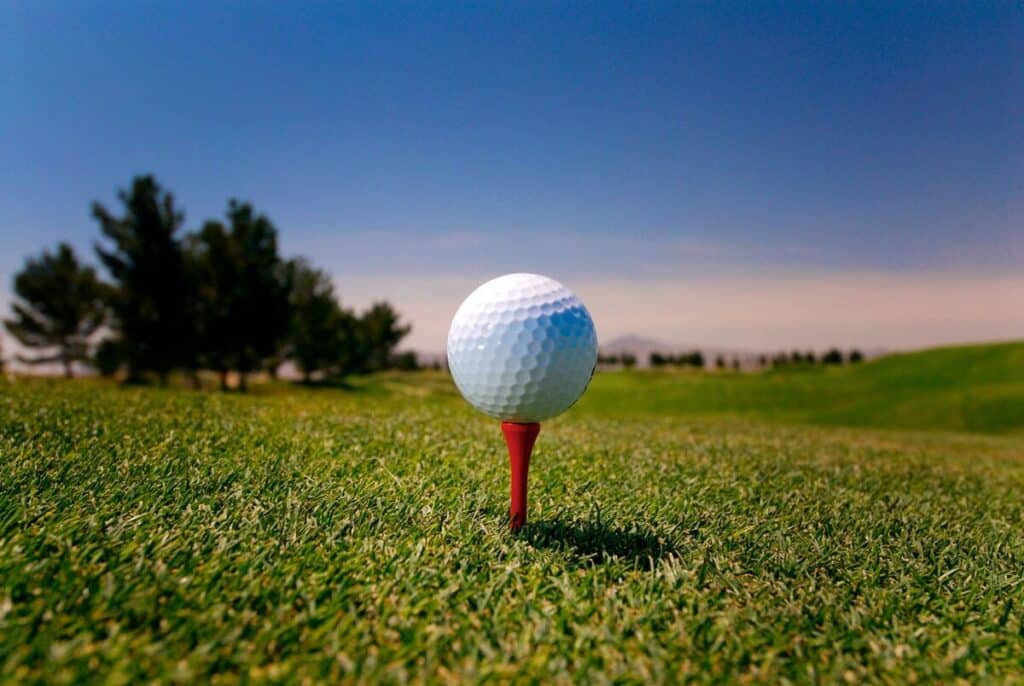 A wide view of golf ball placed on a red tee at a golf course