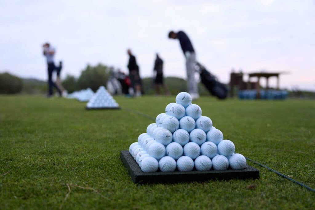 Bunch of golf balls placed in a triangle sequence tray at a golf course