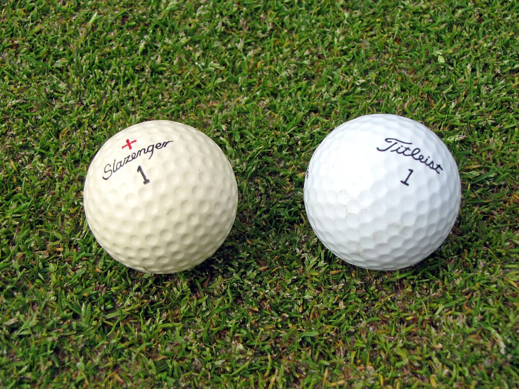 Two golf balls of standard size placed in grass