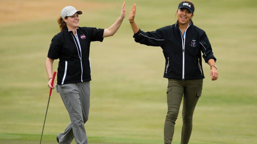 Two golfer women hi fiving one another