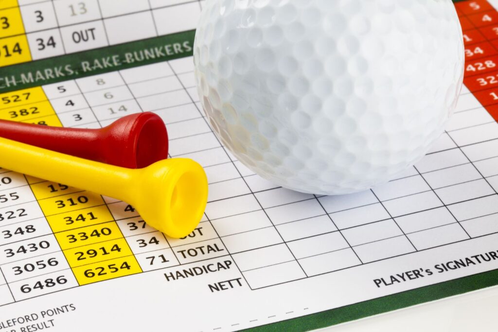 A golf ball with red and yellow tees on a hnadicap index