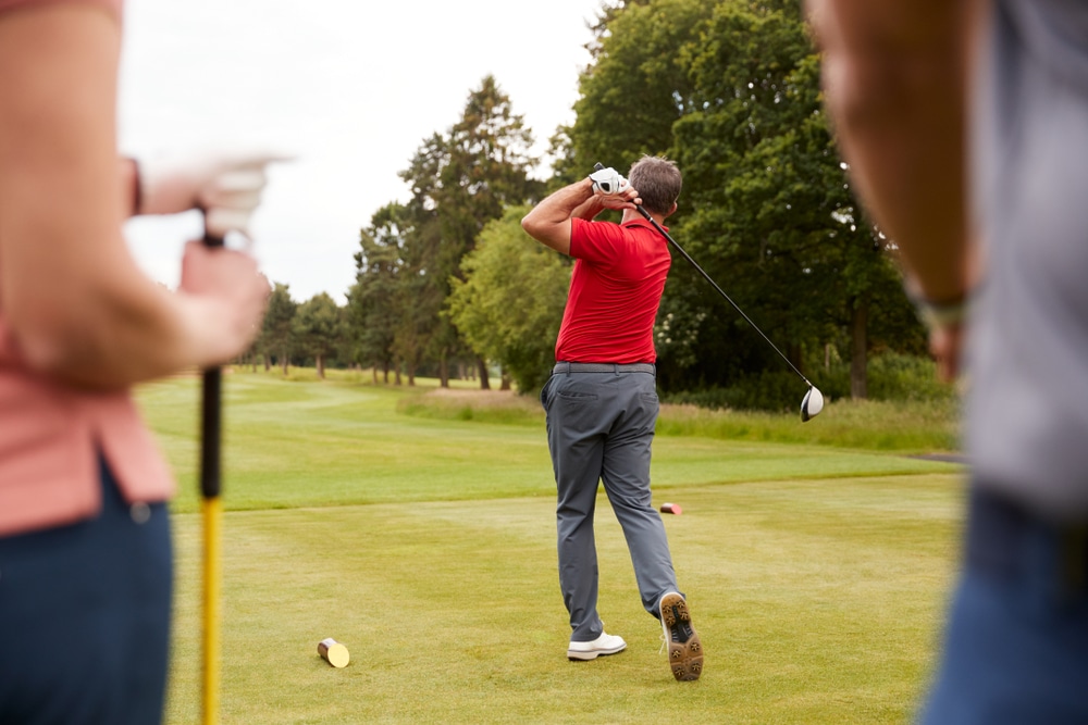 A back view of a guy hitting a golf shot