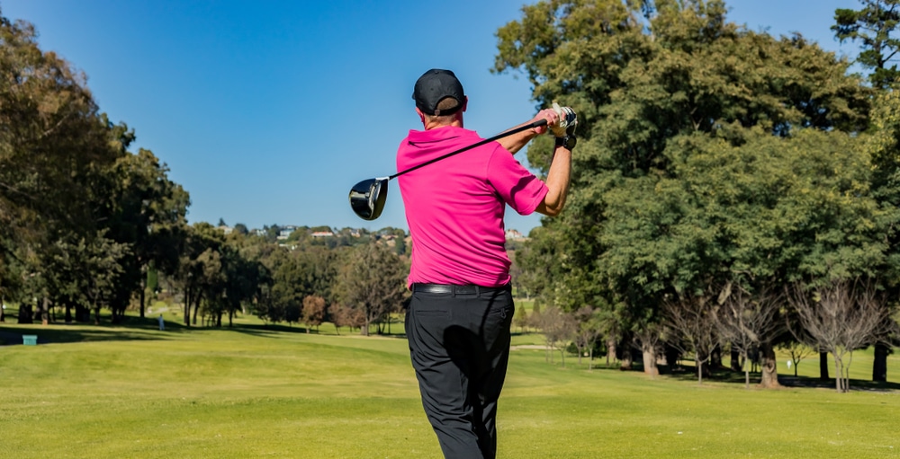 A back view of a person hitting a left hand golf shot