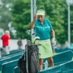 a senior golfer putting teh golf club in the bag