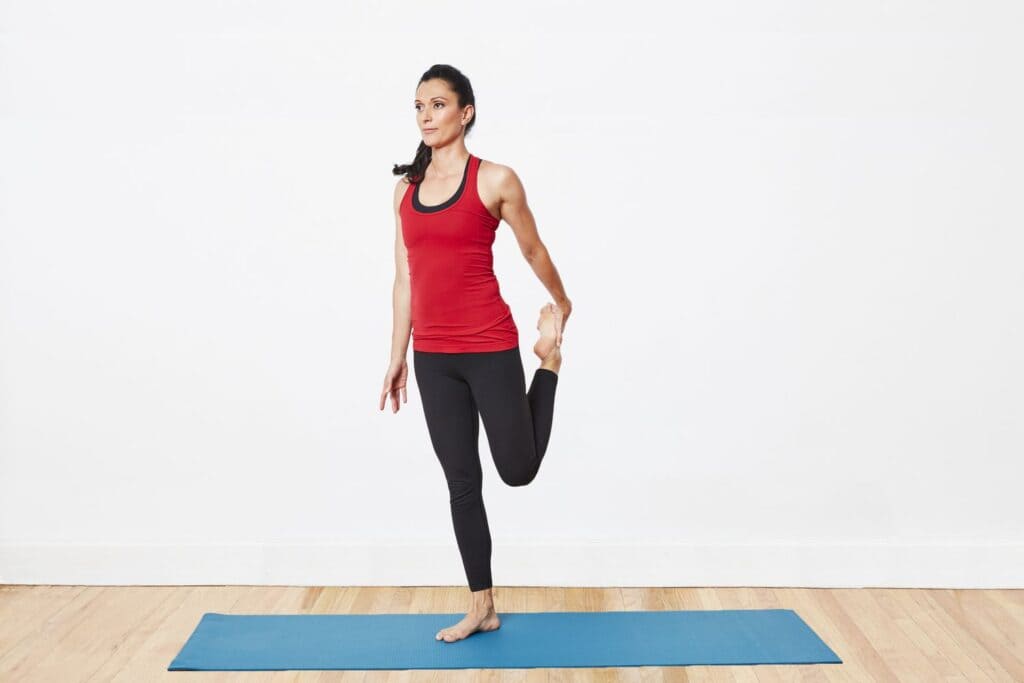 girl standing on a workout mat doing quadriceps