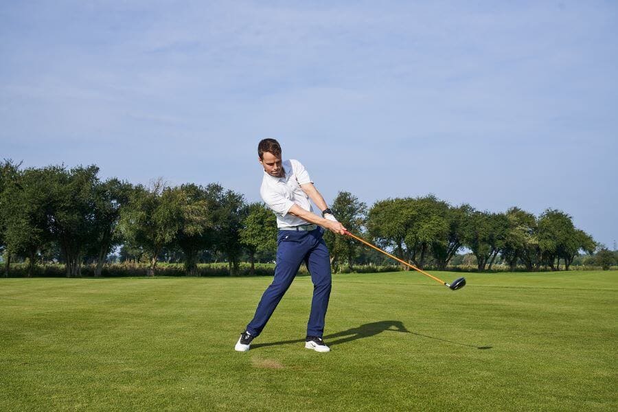 golfer holding a golf club playing golf