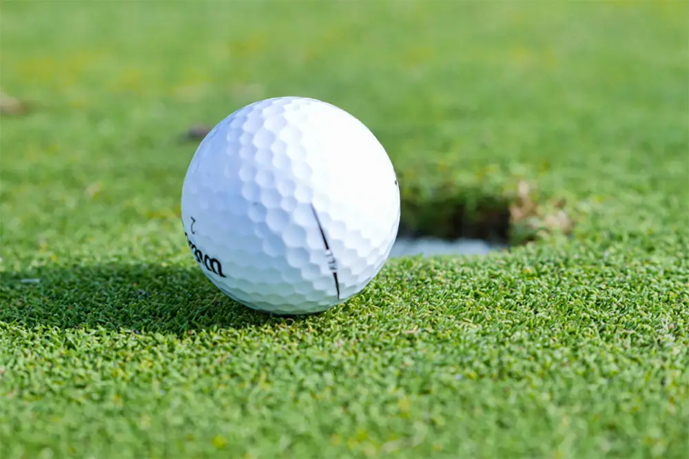 a golf ball near the golf ball hole