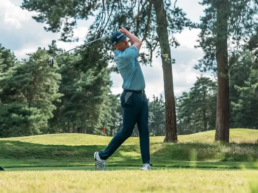 a golf player is playing and hitting the golfball