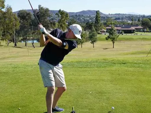 a golfer hitting a draw shot with a club