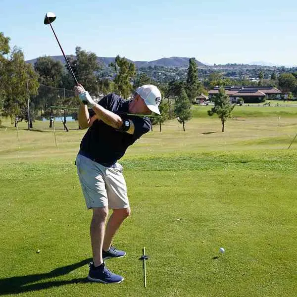 a golfer hitting a draw shot with a club
