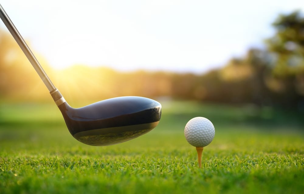 Golf Ball On Tee And Golf Drivers At Golf Course