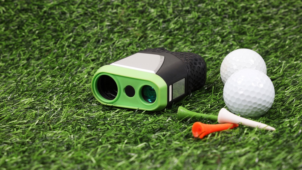 Modern Optical Range Finder And Golf Ball On Artificial Grass