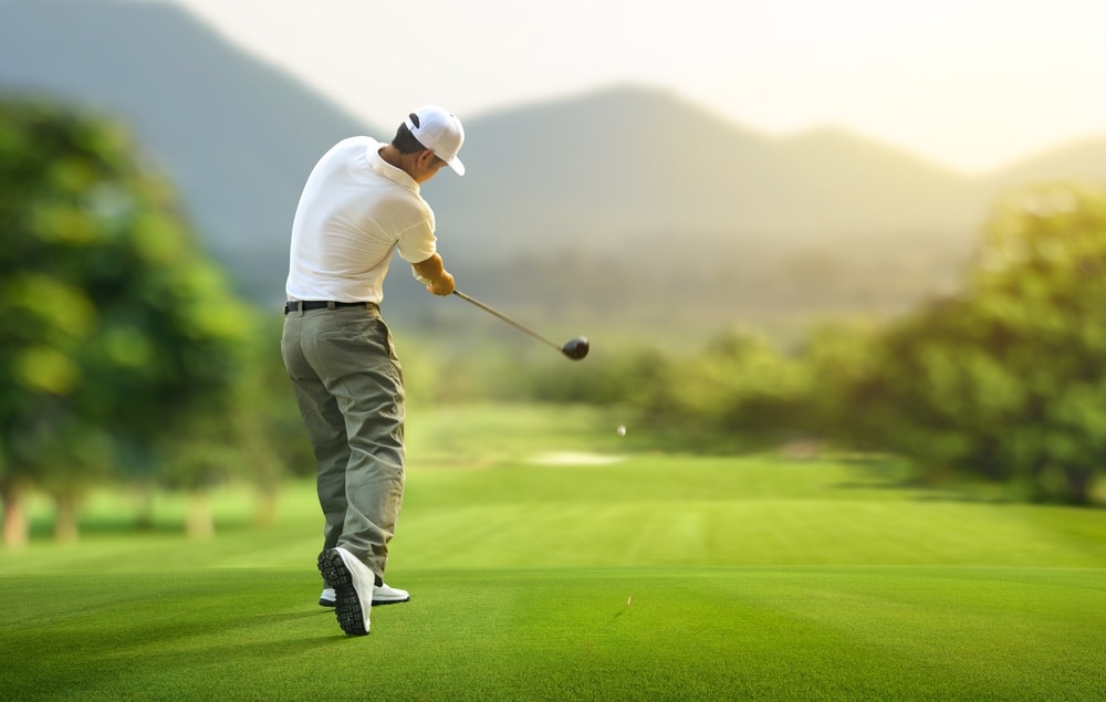 Golfer Hitting Golf Ball With Driver To Fairway