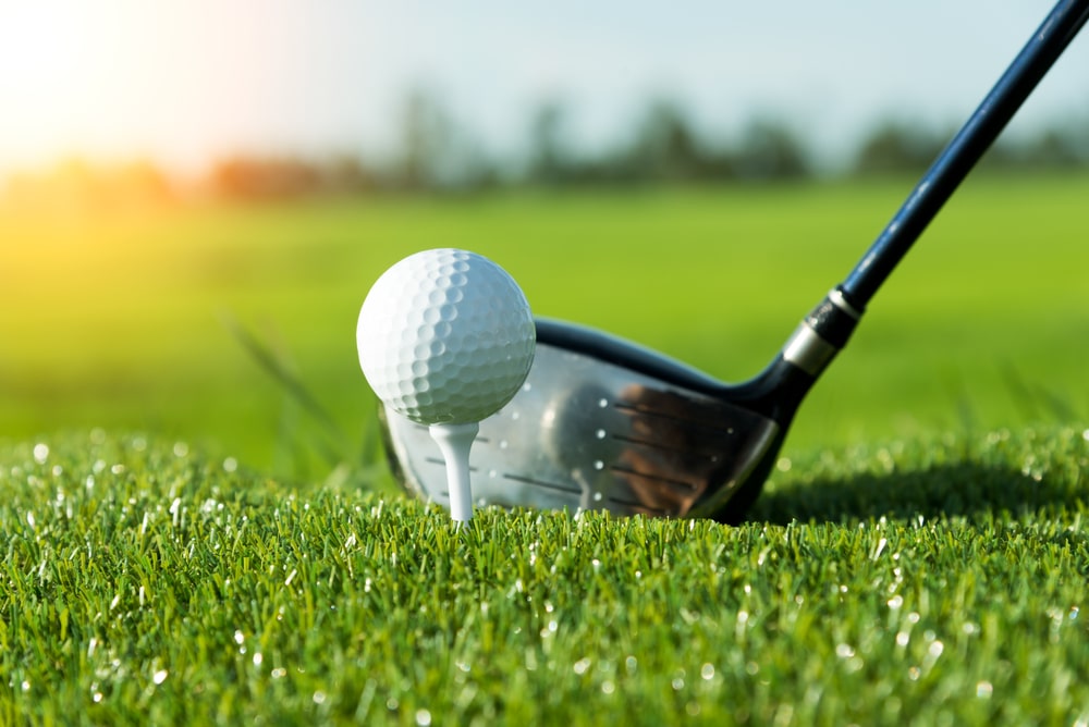 Golf Club And Ball In Grass And Sunset